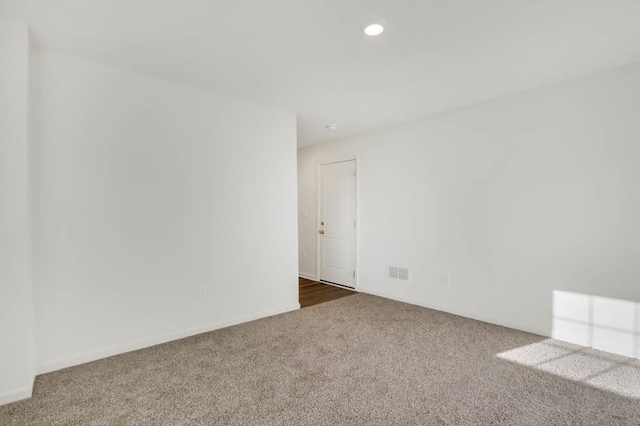 empty room featuring visible vents, baseboards, recessed lighting, and dark colored carpet