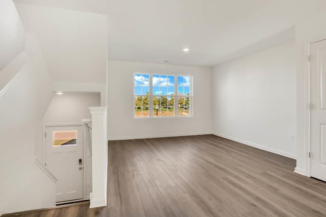 unfurnished living room featuring recessed lighting, baseboards, and wood finished floors