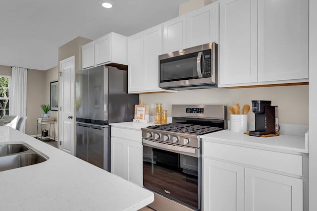 kitchen featuring white cabinetry, recessed lighting, appliances with stainless steel finishes, a sink, and light countertops