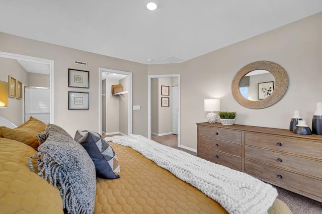 bedroom featuring visible vents, baseboards, a closet, carpet, and a walk in closet