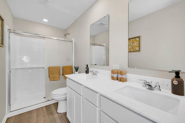 bathroom with a sink, visible vents, toilet, and a shower with shower door