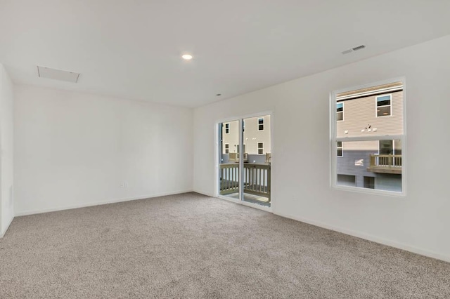 carpeted empty room featuring visible vents and baseboards
