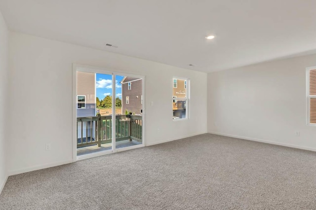 spare room with visible vents, baseboards, and carpet