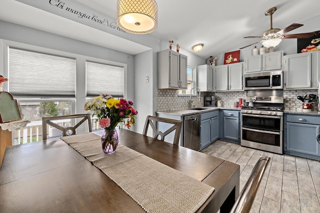 208 Sprucewood Ct, Round Lake Beach, IL 60073 - kitchen featuring appliances with stainless steel finishes, a sink, a ceiling fan, tasteful backsplash, and vaulted ceiling