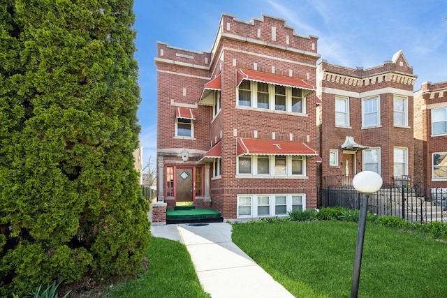 130 S Mason Ave, Chicago, IL 60644 - view of front facade with brick siding, fence, and a front lawn