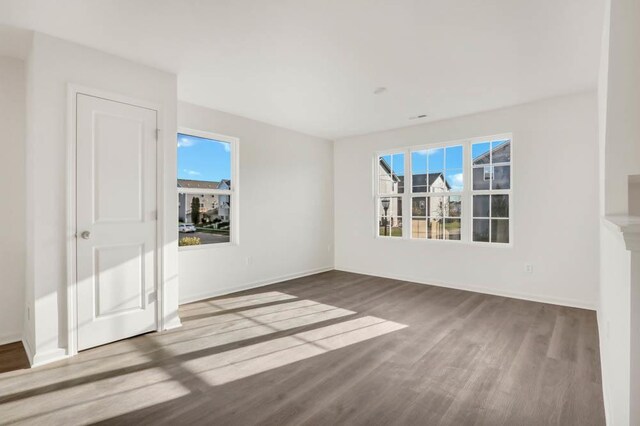 interior space featuring wood finished floors, baseboards, and multiple windows