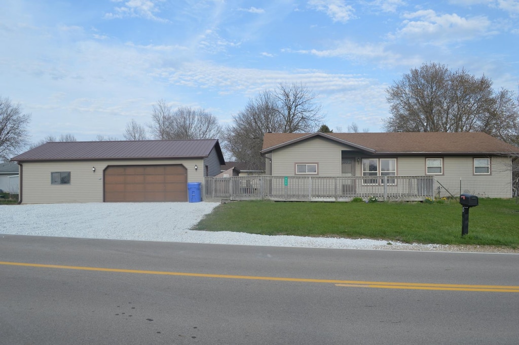 ranch-style house featuring a front yard, fence, a garage, and an outbuilding