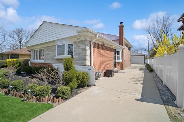 9249 Kildare Ave, Skokie, IL 60077 - view of side of home featuring a garage, a chimney, an outdoor structure, and brick siding