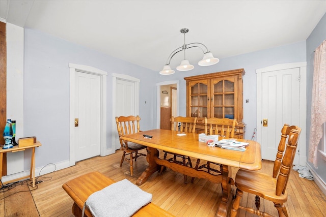 2142 N Mobile Ave, Chicago, IL 60639 - dining area featuring light wood-type flooring, baseboards, and a chandelier
