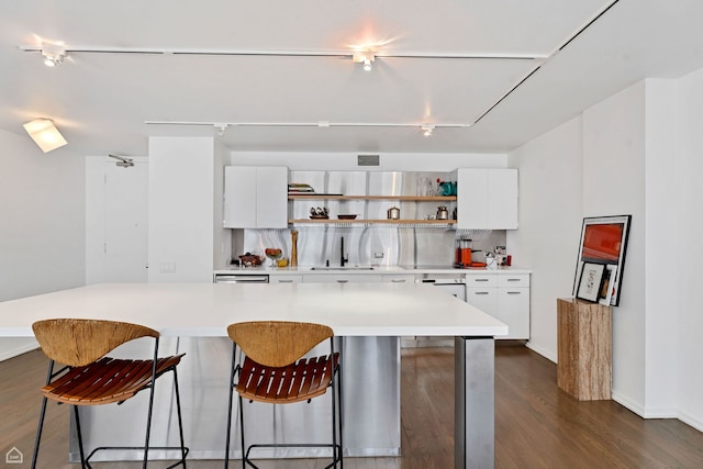 kitchen featuring white cabinets, a breakfast bar area, open shelves, and dark wood finished floors