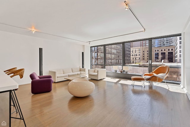 living area with a city view, wood finished floors, and baseboards