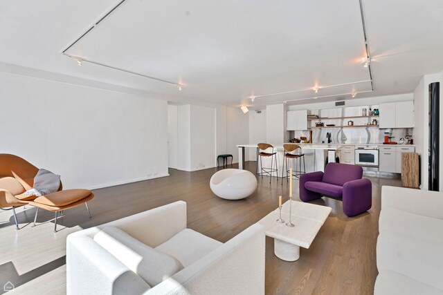 living room with wood finished floors, attic access, rail lighting, and visible vents
