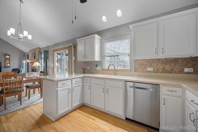 kitchen with a peninsula, dishwasher, a wealth of natural light, and a sink