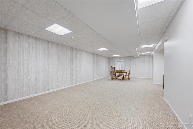 finished below grade area featuring carpet flooring and a paneled ceiling