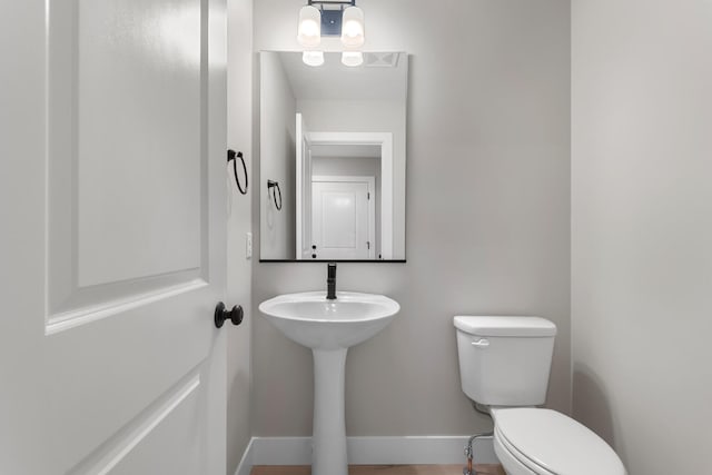 bathroom featuring baseboards and toilet
