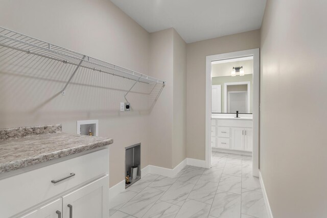 clothes washing area featuring marble finish floor, baseboards, cabinet space, washer hookup, and hookup for an electric dryer