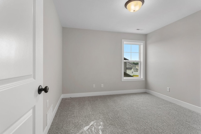 empty room featuring baseboards, carpet, and visible vents