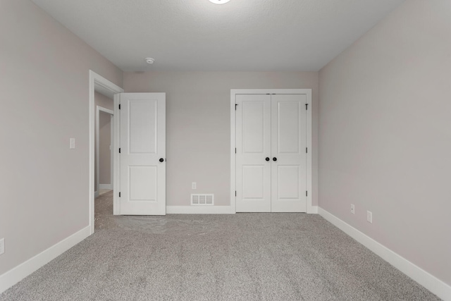 unfurnished bedroom featuring visible vents, baseboards, and carpet floors