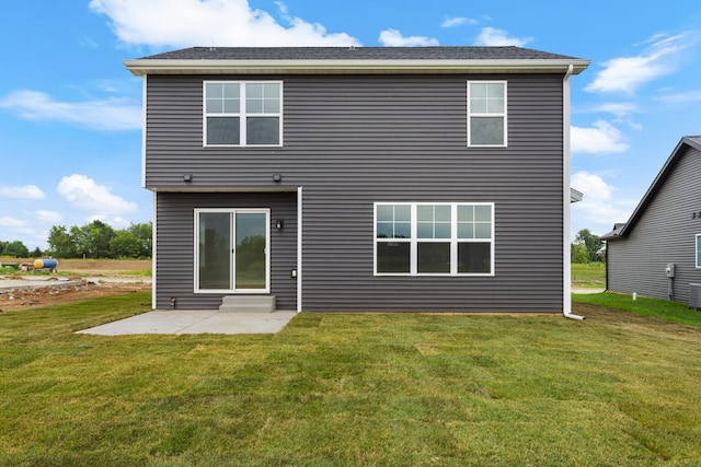 rear view of house with a lawn and a patio