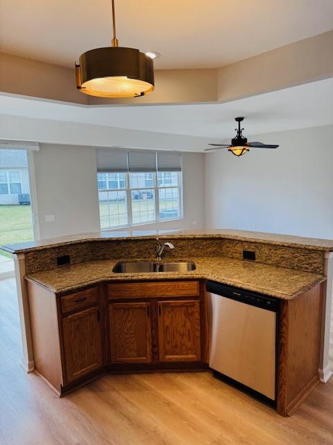 11246 Bellflower Ln, Huntley, IL 60142 - kitchen featuring dark stone countertops, dishwasher, a sink, ceiling fan, and light wood-style flooring