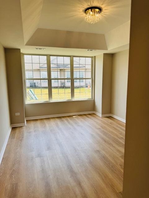 11246 Bellflower Ln, Huntley, IL 60142 - empty room with a wealth of natural light, a raised ceiling, wood finished floors, and baseboards