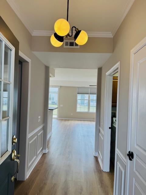 11246 Bellflower Ln, Huntley, IL 60142 - hallway with visible vents, crown molding, and wood finished floors
