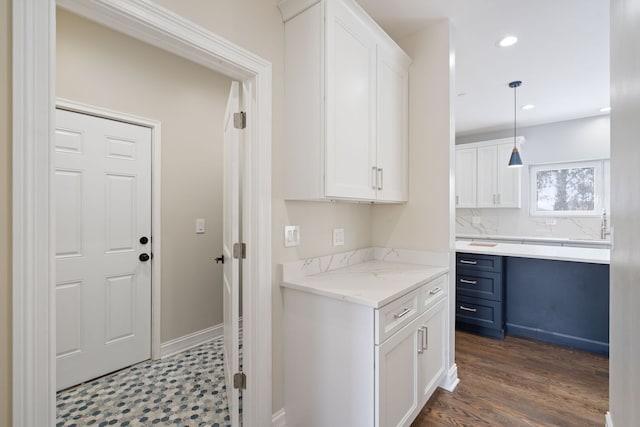 kitchen featuring white cabinets, recessed lighting, pendant lighting, and light stone counters