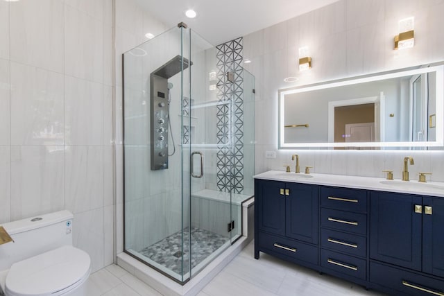 full bath with a sink, tile walls, a stall shower, and toilet