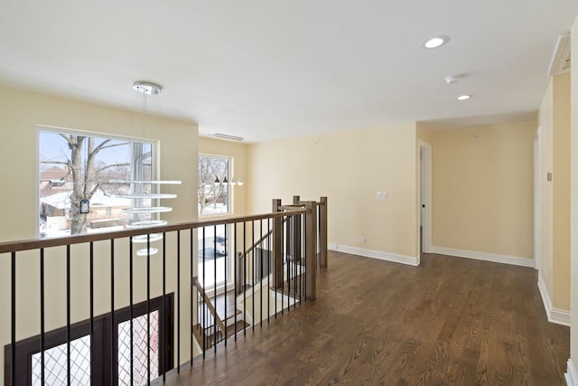 corridor with baseboards, an upstairs landing, recessed lighting, and dark wood finished floors