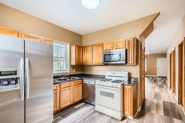 8151 S Bennett Ave, Chicago, IL 60617 - kitchen featuring light wood-style floors, a sink, dark countertops, and stainless steel appliances