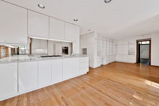 kitchen featuring built in refrigerator, stainless steel oven, white cabinetry, light wood-type flooring, and recessed lighting