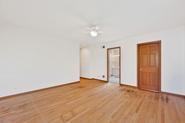 spare room featuring baseboards, a ceiling fan, and light wood-style floors