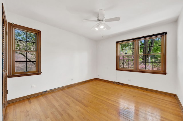 spare room featuring healthy amount of natural light, light wood finished floors, baseboards, and ceiling fan