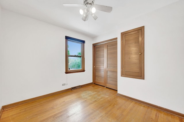 unfurnished bedroom with baseboards, light wood-style floors, a closet, and a ceiling fan
