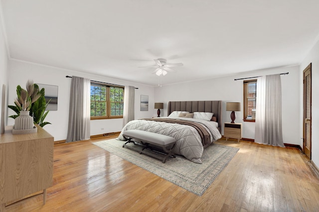 bedroom with light wood-type flooring, baseboards, and a ceiling fan