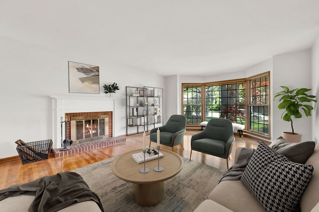living room with wood finished floors, a fireplace, and baseboards