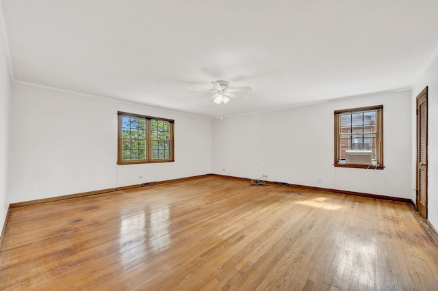 empty room featuring a ceiling fan, light wood-type flooring, baseboards, and ornamental molding
