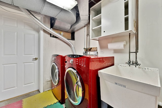 clothes washing area featuring washer and dryer and a sink