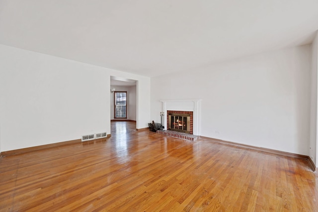 unfurnished living room featuring light wood-style floors, a fireplace, and baseboards