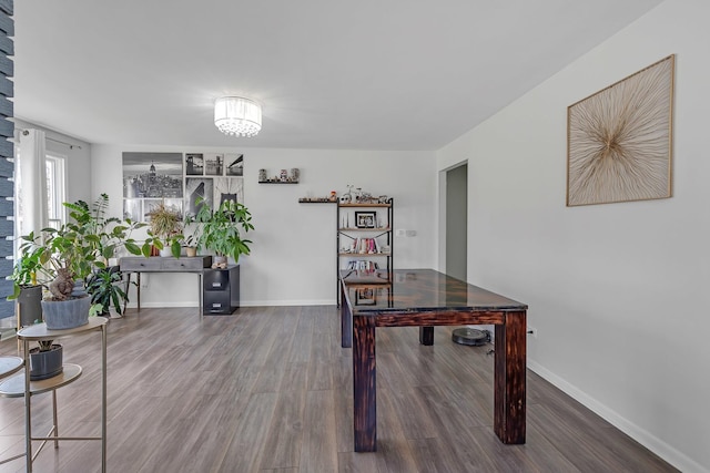 interior space featuring baseboards, a chandelier, and wood finished floors