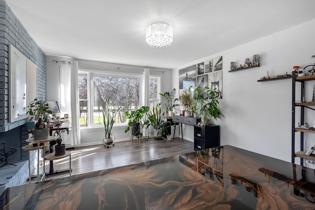 living area with wood finished floors, a notable chandelier, and baseboards