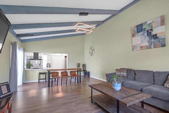 living room with wood finished floors, lofted ceiling with beams, and baseboards