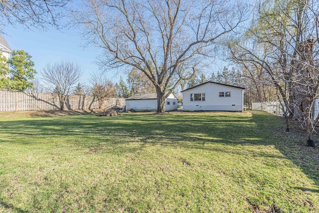 view of yard with fence and an outbuilding