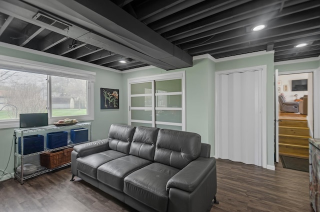 living area featuring visible vents and wood finished floors