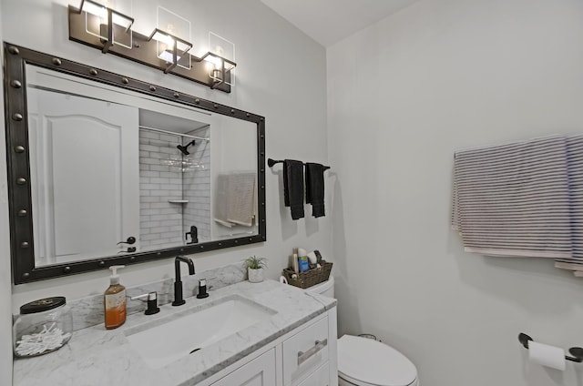 bathroom featuring vanity, walk in shower, and toilet