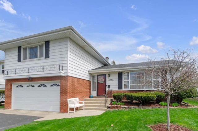 split level home with a garage, brick siding, driveway, and a front lawn
