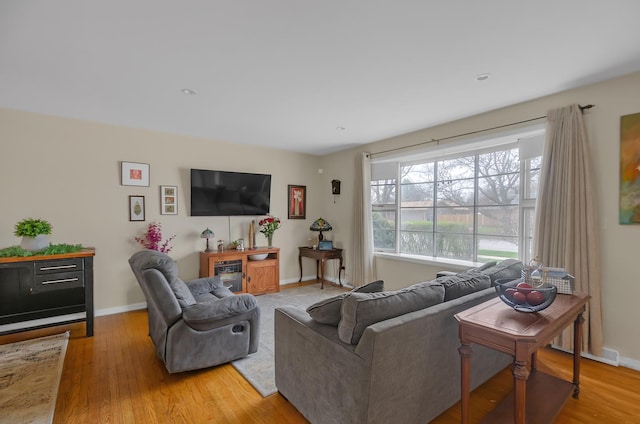 living area with visible vents, light wood-type flooring, and baseboards