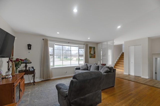 living room with recessed lighting, baseboards, stairs, and wood finished floors