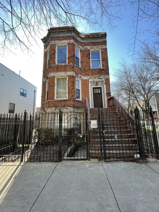 1022 N Rockwell St, Chicago, IL 60622 - view of front of house featuring brick siding, a gate, and a fenced front yard