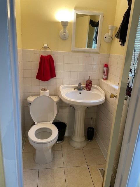 1531 N 9th Ave, Melrose Park, IL 60160 - bathroom with toilet, tile walls, tile patterned floors, a wainscoted wall, and a sink